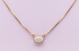 A 9 ct gold and opal pendant on chain. The pendant 9 mm wide. 3 grammes total weight.