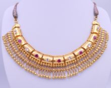 An Indian 22 ct gold ruby and white sapphire necklace. The frontispiece 15.5 cm wide. 37.