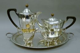 A four piece silver tea set and a plated tray. The teapot 31 cm long. 57.