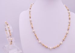 An unmarked gold and pearl necklace with matching bracelet, makers mark JKB.