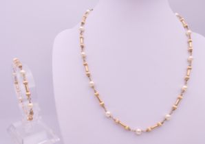 An unmarked gold and pearl necklace with matching bracelet, makers mark JKB.
