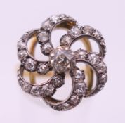 An 18 ct gold and diamond swirling cluster ring. Ring size P.