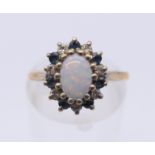 A 9 ct gold opal and sapphire ring. Ring size L/M.