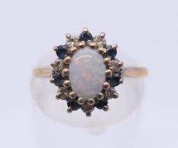 A 9 ct gold opal and sapphire ring. Ring size L/M.