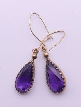 A pair of gold and amethyst drop earrings. 2 cm high.