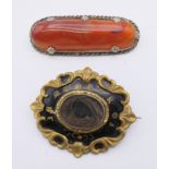 A Victorian mourning brooch and an agate set brooch. The former 5 cm wide.