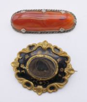 A Victorian mourning brooch and an agate set brooch. The former 5 cm wide.