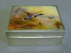 A silver cigarette box, the lid inset with a plaque painted with ducks taking flight. 11 cm long.
