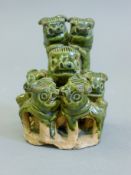 A Chinese green pottery dog group. 9 cm high.