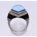 An 18 ct white gold blue topaz, diamond and onyx ring. Ring size P. 2.25 cm wide.
