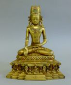 A gilt bronze model of Buddha mounted with cabochons. 22.5 cm high.