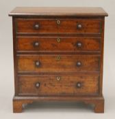 A miniature mahogany chest of drawers. 23 cm wide.