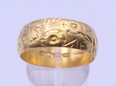 A 22 ct gold engraved wedding band. Ring size V/W. 10 grammes.