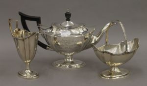 An associated three piece silver tea set, the teapot bearing description. 26.5 cm long. 684.
