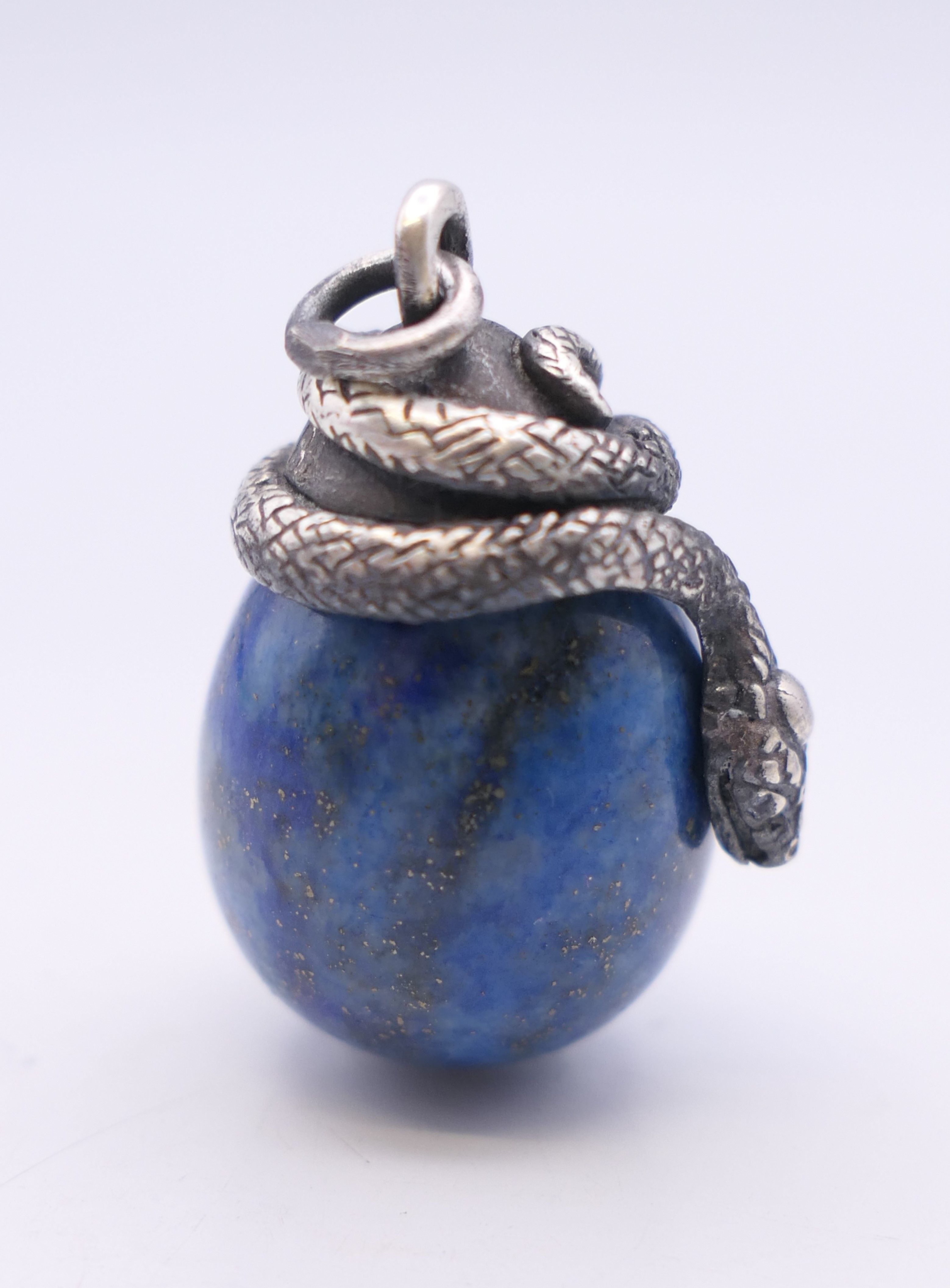 A lapis egg form pendant surmounted with a snake, bearing Russian marks. 2.5 cm high. - Image 3 of 4