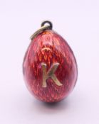 A red enamel egg form pendant. 2 cm high.