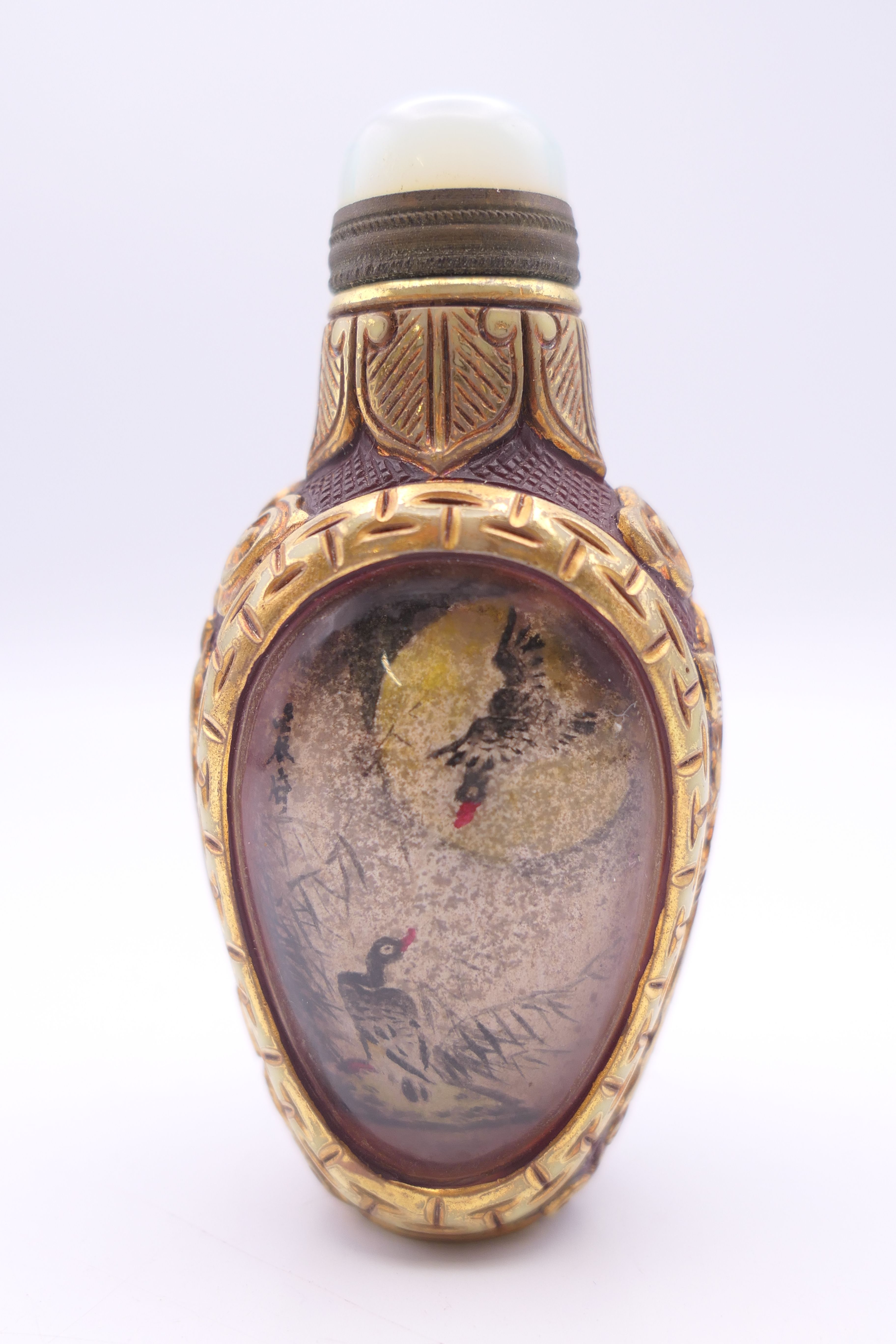 A Chinese gilded glass snuff bottle, inside painted duck scenes, artist Ding Erzhong,