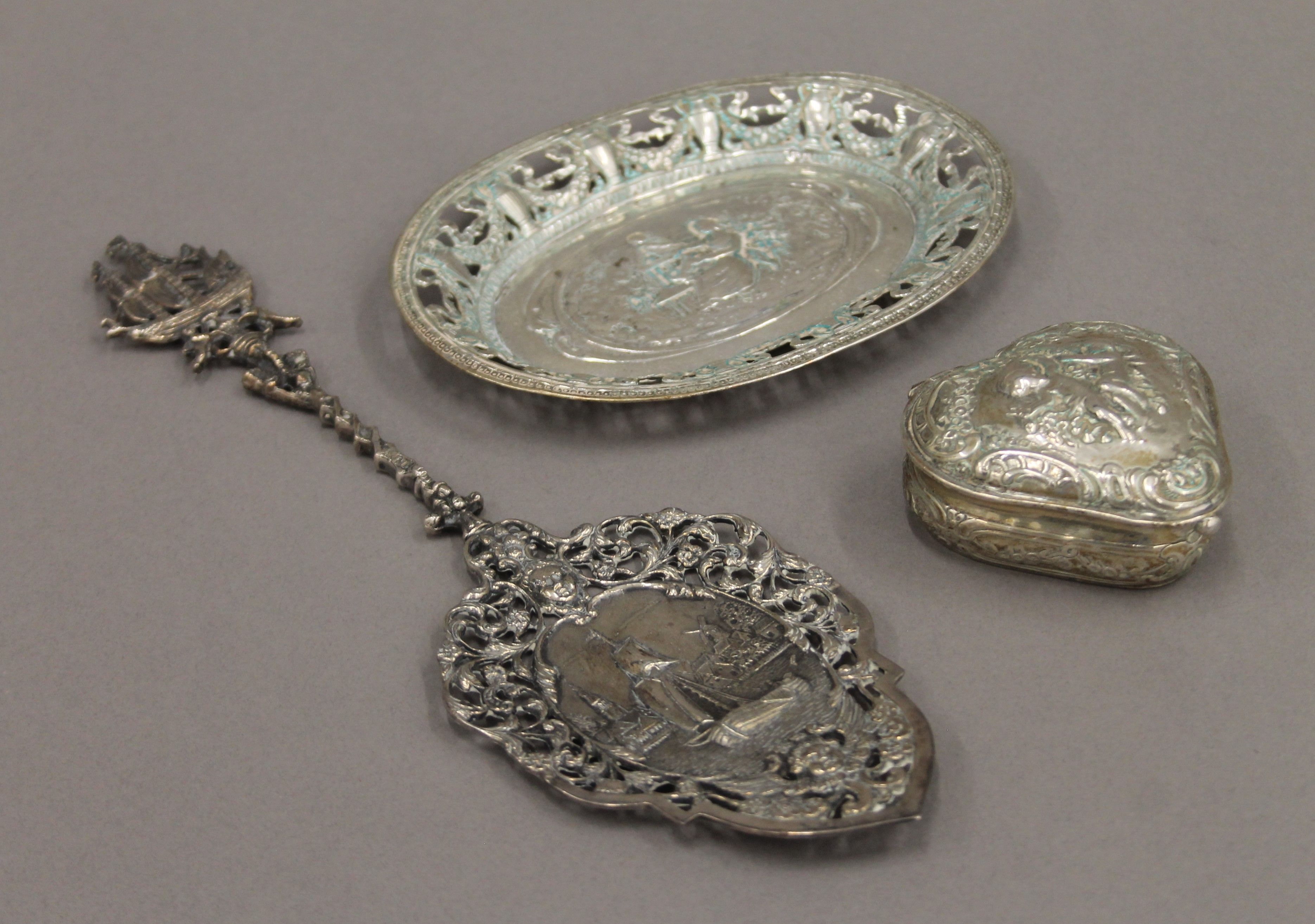 A Dutch silver heart shaped box, a small silver tray and a silver spoon. The former 6.5 cm wide.