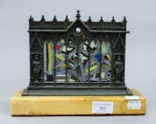 A Gothic Revival bronze and stained glass centrepiece mounted on a sienna marble plinth base.