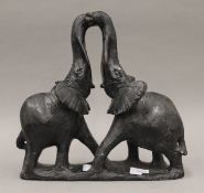 A carved stone model of two elephants with entwined trunks. 33.5 cm high.