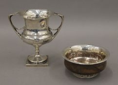 A twin handled silver trophy cup and an Eastern white metal mounted bowl. The former 13 cm high.