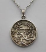 A Chinese cast silver pendant and chain with pagoda and figure decoration. The pendant 3.