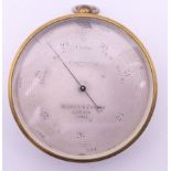 A Negretti & Zambra of London brass barometer, in original case, numbered 17423. 7 cm diameter.