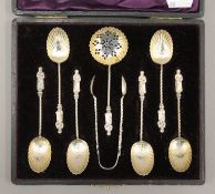 A boxed silver set of teaspoons, tongs and a sifter spoon. The case 19 cm wide. 61.7 grammes.