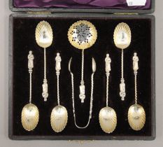 A boxed silver set of teaspoons, tongs and a sifter spoon. The case 19 cm wide. 61.7 grammes.