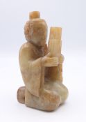 A Chinese light green and russet jade figure of a man playing a musical instrument, Western Han. 8.