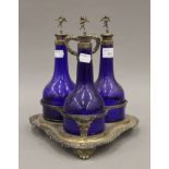 A silver plated three bottle decanter stand with three glass bottles. 27.5 cm high.