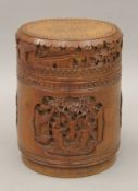 A Chinese cylindrical bamboo box, carved in the round with various scenes,