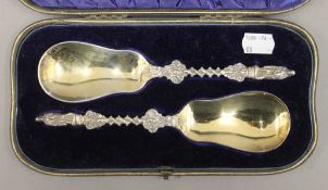 A cased pair of silver Apostle serving spoons. Each 20 cm long. 143.6 grammes.
