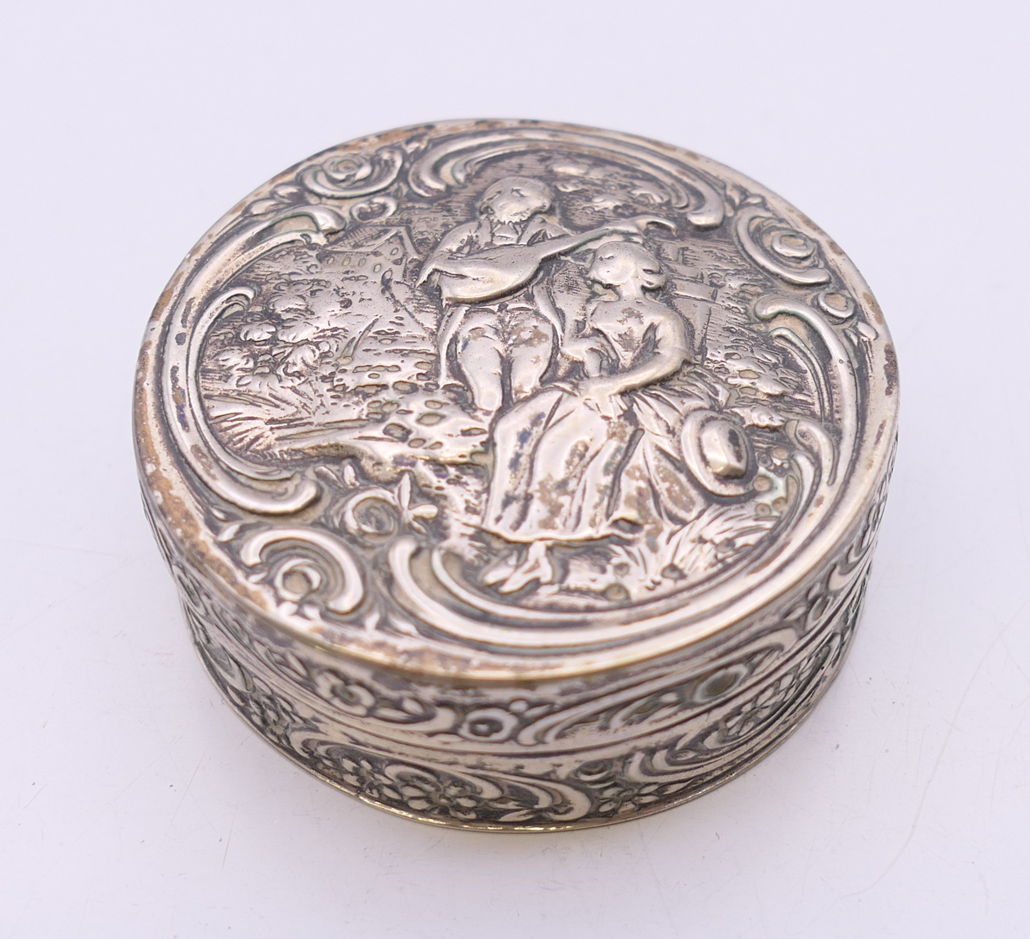 A embossed Continental silver box. 5 cm diameter. 44.3 grammes.