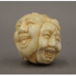 A bone ball formed as various faces. 3.5 cm high.