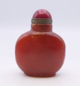 A small Chinese reddish brown agate snuff bottle, with red stopper. 5.5 cm high.