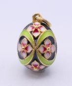 A silver gilt enamel egg form pendant, bearing Russian marks. 2 cm high.