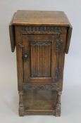 An early 20th century oak linen fold side cupboard with twin flap top. 43.5 cm wide flaps down.