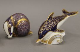 A Royal Crown Derby badger form paperweight and a Royal Crown Derby dolphin form paperweight.