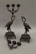 A pair of late 19th/early 20th century Japanese bronze patinated candlesticks formed as cranes.