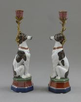 A pair of gilt metal mounted porcelain candlesticks formed as dogs. 33.5 cm high.