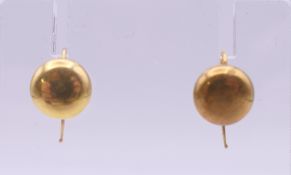 A cased pair of unmarked gold earrings. 9 mm diameter. 1.2 grammes.
