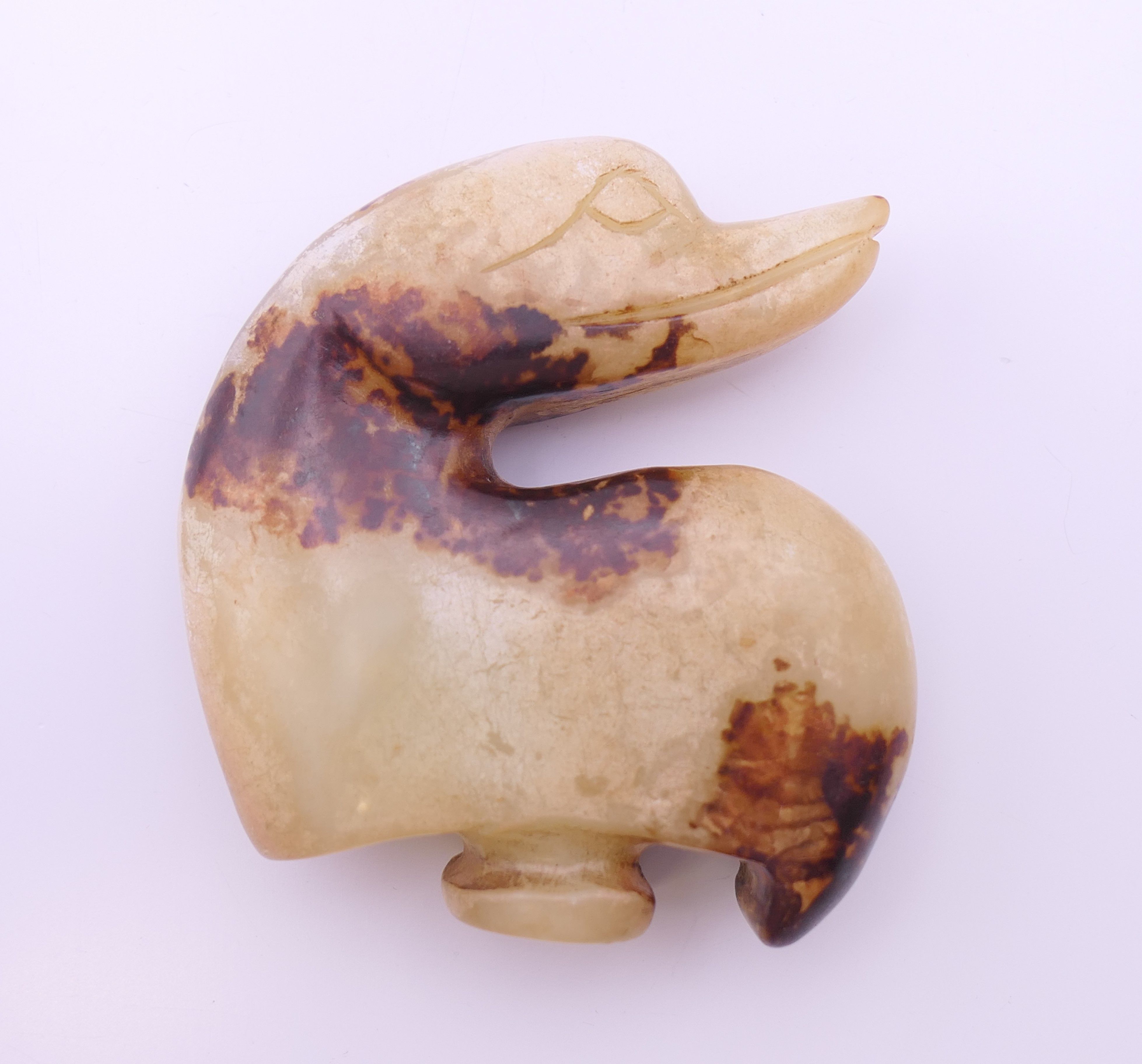 A Chinese off white and brown jade duck belt hook, Ming Dynasty. 5.5 cm high.