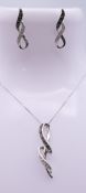 A 9 ct white gold and diamond pendant with matching earrings. The pendant 2.5 cm high.