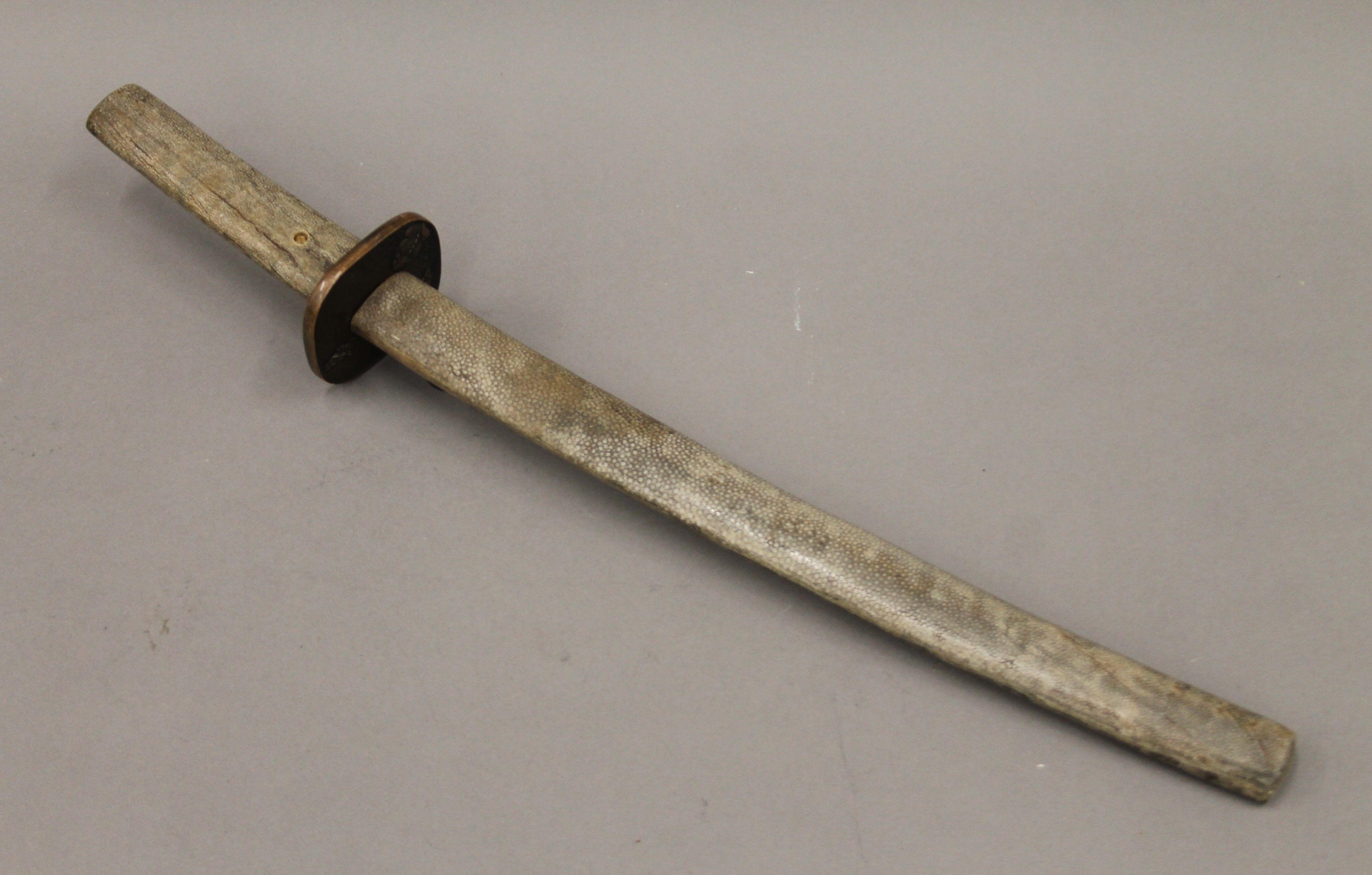 A Japanese sword with shagreen scabbard. 60 cm long.