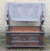 A Victorian carved oak monks bench. 90 cm long.