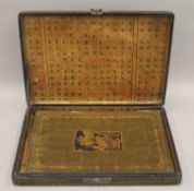 A cased set of Chinese decorative place mats. The box 40 cm wide.