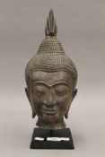 A large bronze bust of Buddha, mounted on a display stand. 41 cm high.