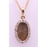 A 9 ct gold and diamond oval pendant on a 9 ct gold chain. Pendant 1.