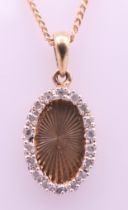 A 9 ct gold and diamond oval pendant on a 9 ct gold chain. Pendant 1.